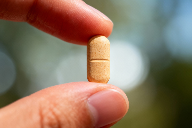 عوارض قرص اپتی وومن گلدن لایف - تصویر قرص در دست